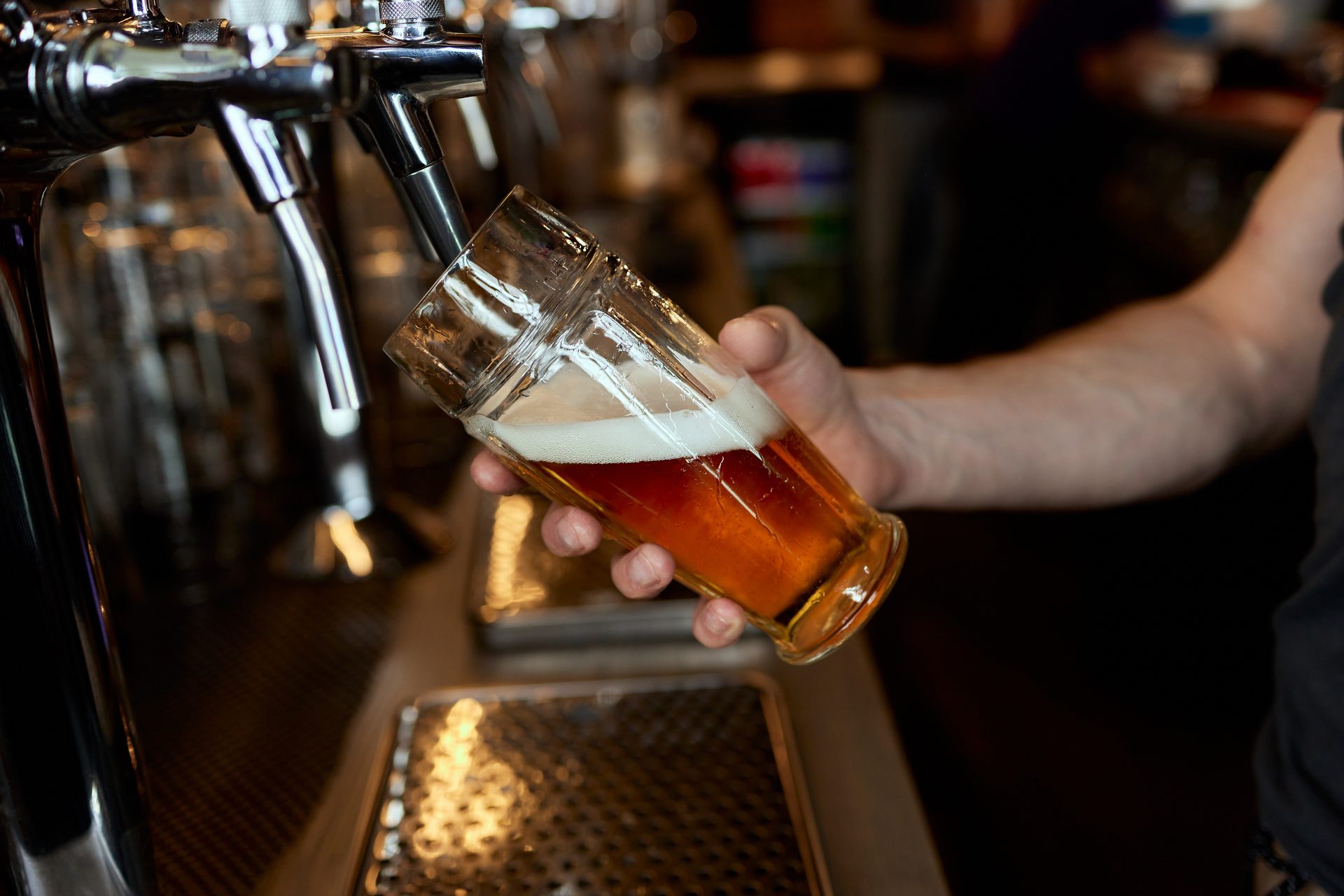 Bartender pouring a draft beer from the tap