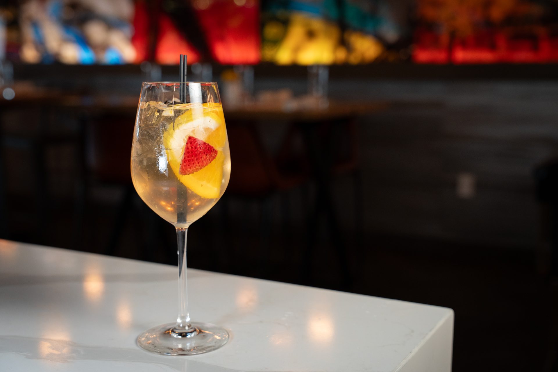 White wine spritzer garnished with strawberry and citrus